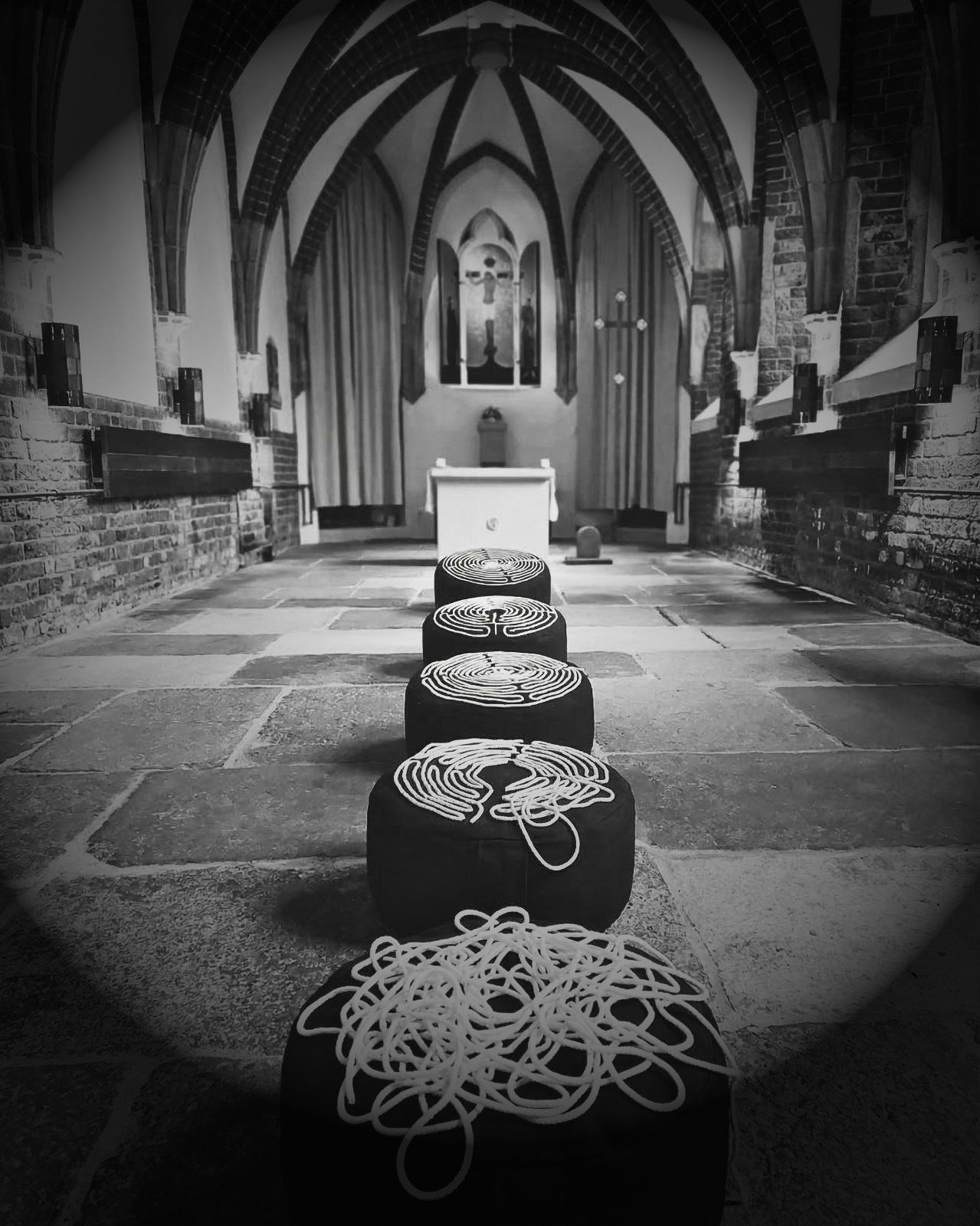 Poduszki do medytacji z labiryntowym wzorem sznura w nawie kościoła